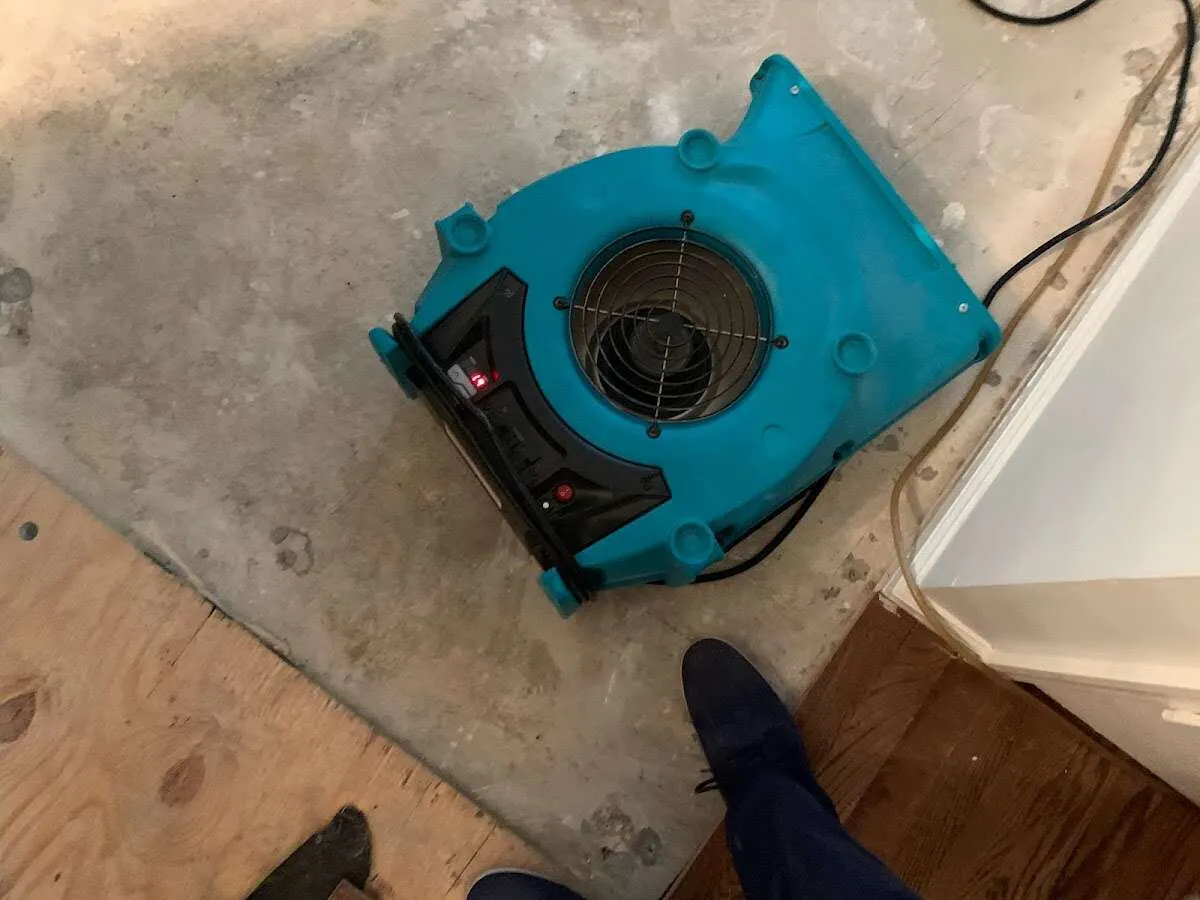 Air mover drying subfloor during Commercial Water Damage Restoration in Mendon